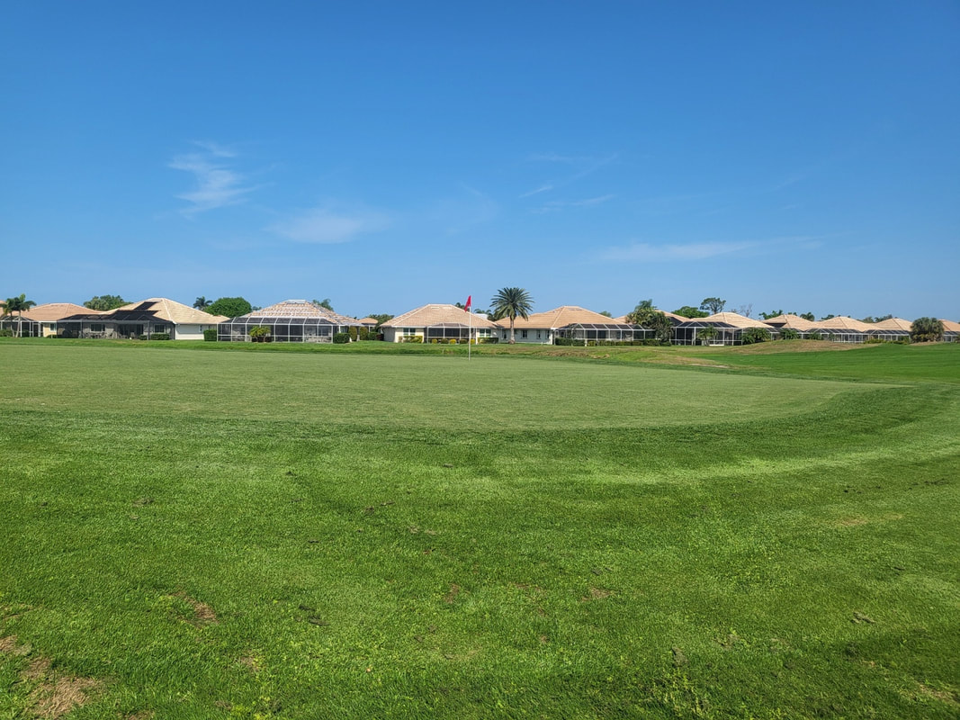 Golf course fairway with neighborhood in distance